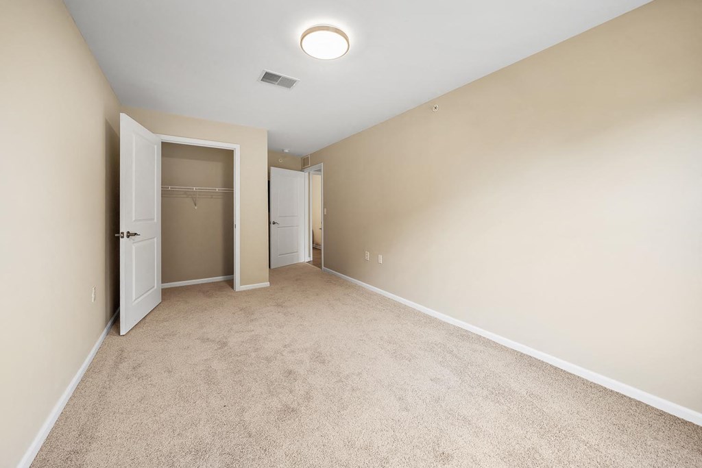 an empty room with a closet and a door to a bathroom