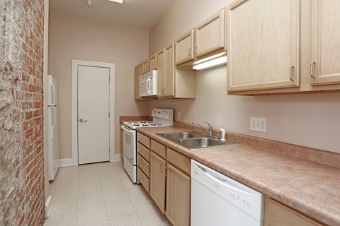 A kitchen with a white dishwasher and a white fridge.