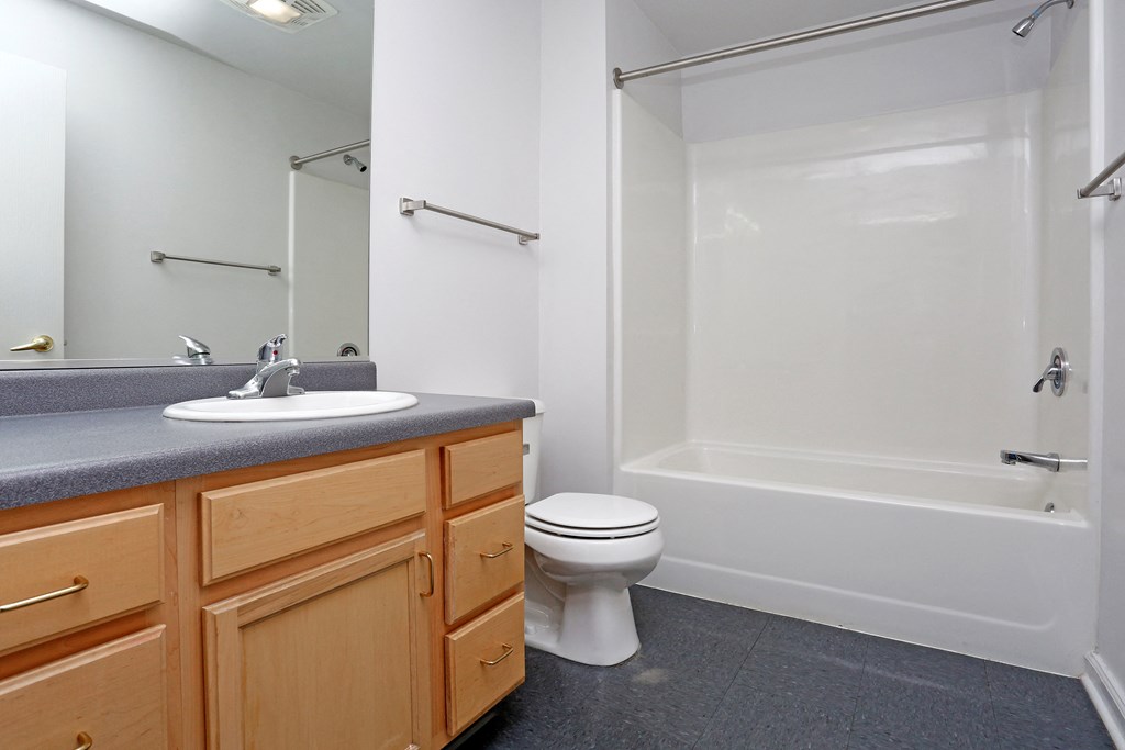 A bathroom with a toilet, sink, and bathtub.