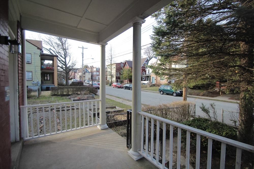 a view of a street from the porch of a house