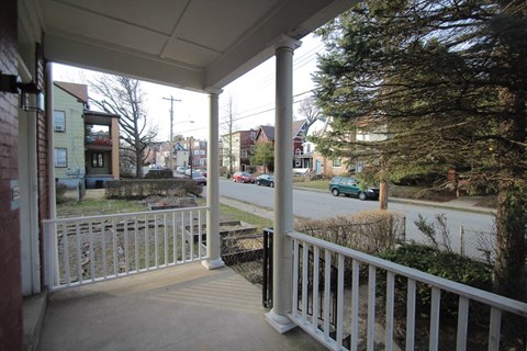 a view of a street from the porch of a house