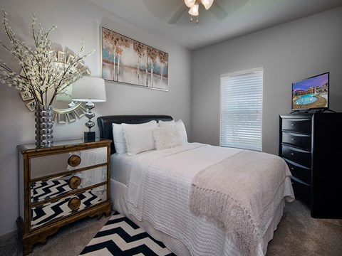 a bedroom with a bed and a dresser and a window