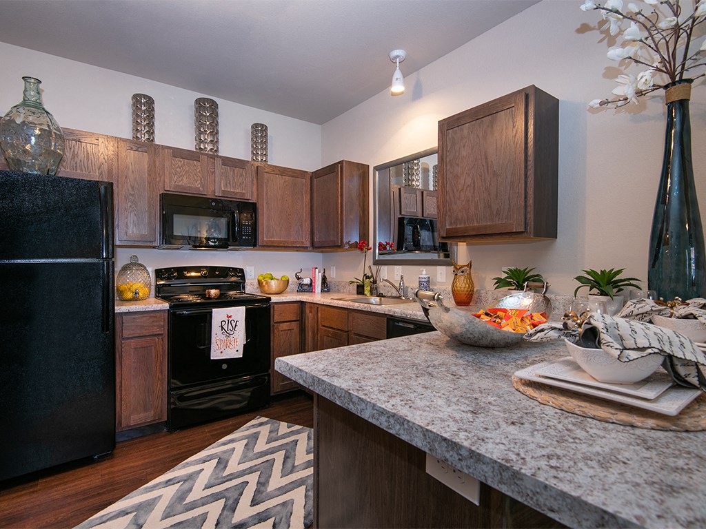 a kitchen with a granite counter top and a black refrigerator