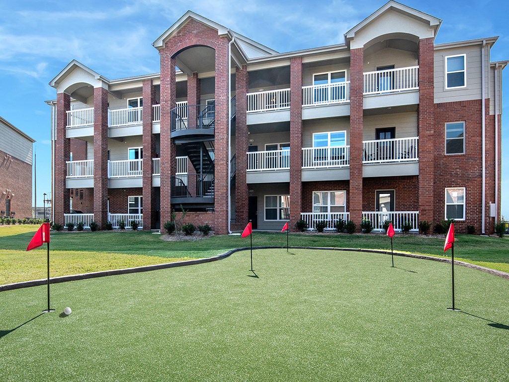 an exterior view of an apartment building with a golf course