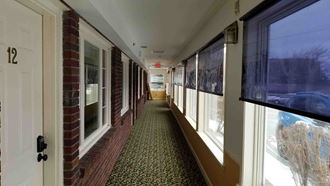 a hallway in a building with windows and a door