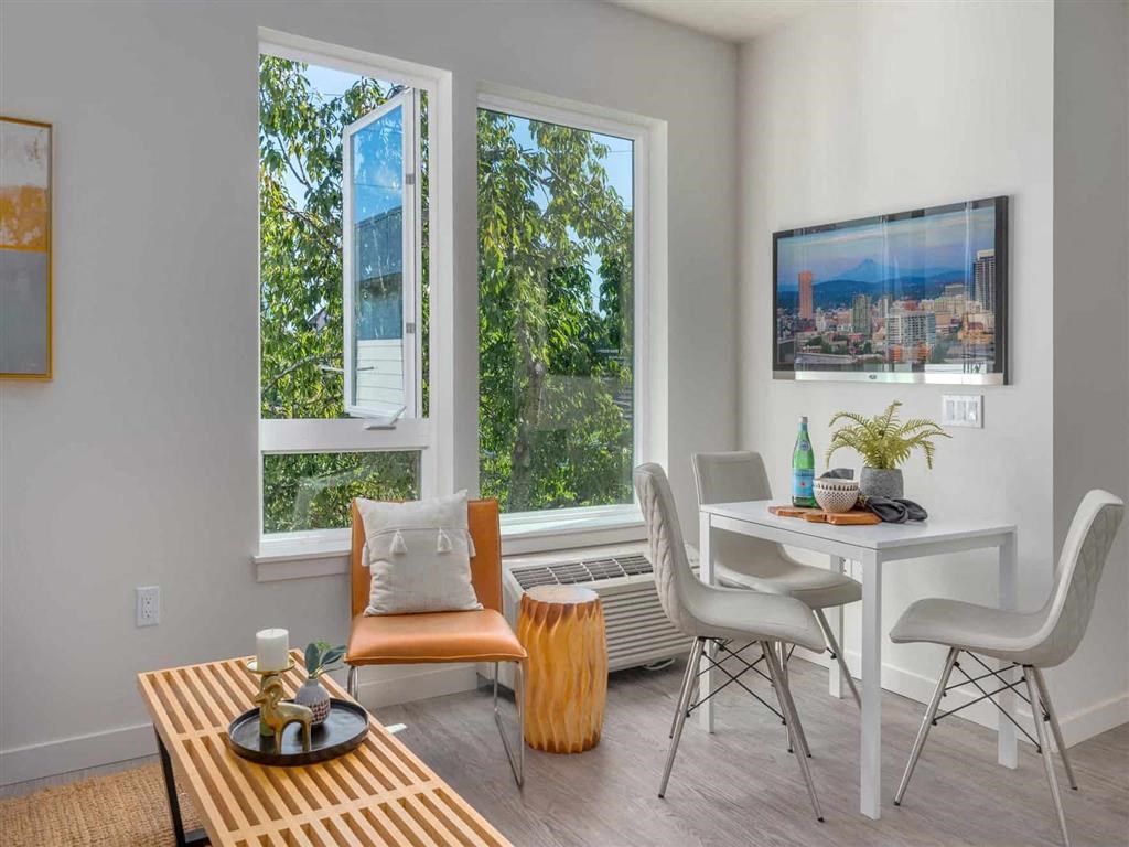 Living rooms with modern finishes and oversized windows at Acqua Apartments.