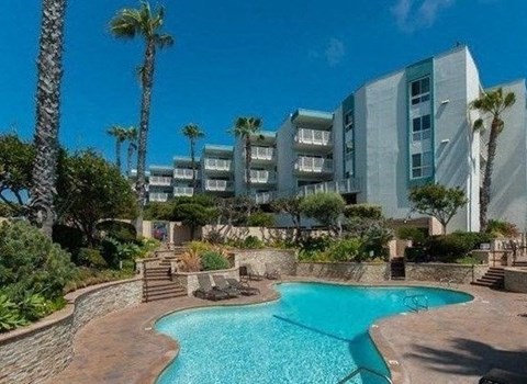 a large swimming pool with buildings in the background