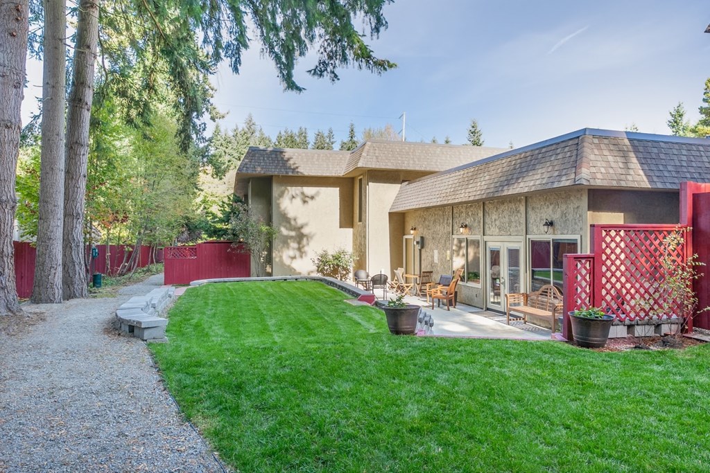 a backyard with a house and a lawn