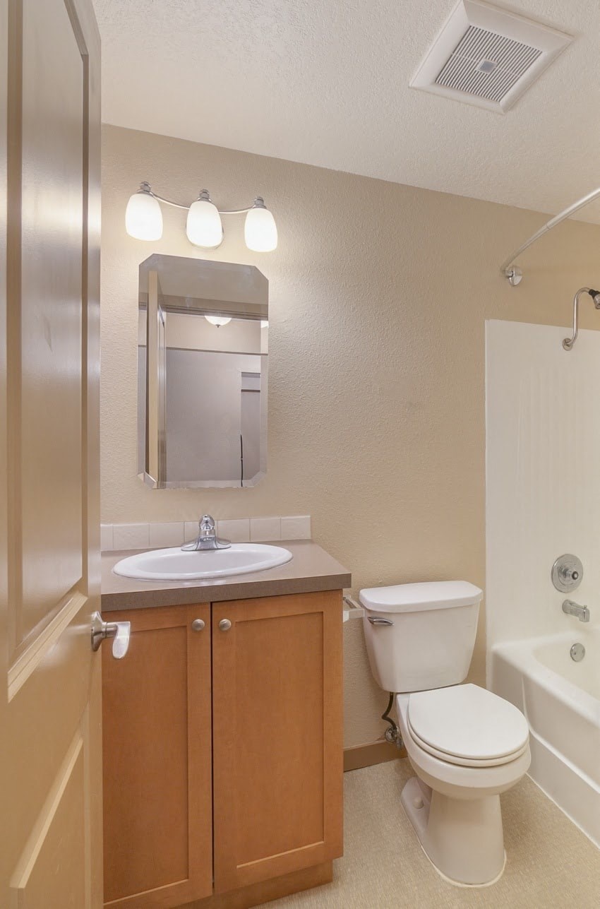 a bathroom with a toilet and a sink and a bath tub