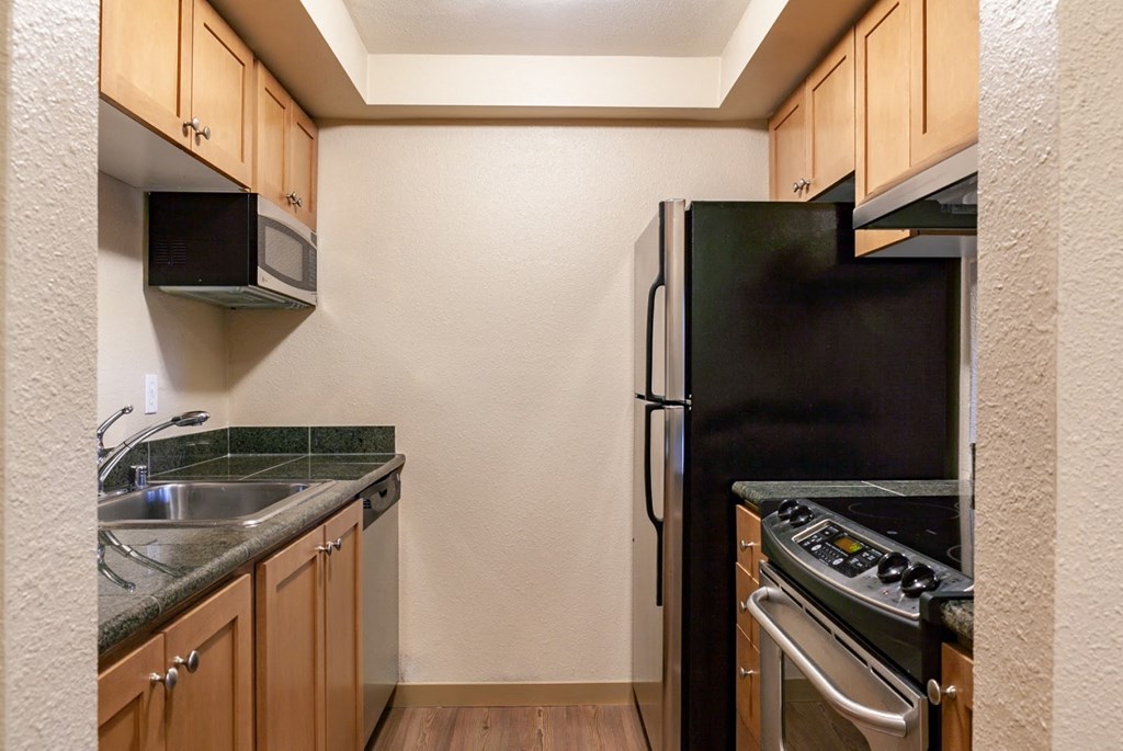 a kitchen with a stove refrigerator and sink