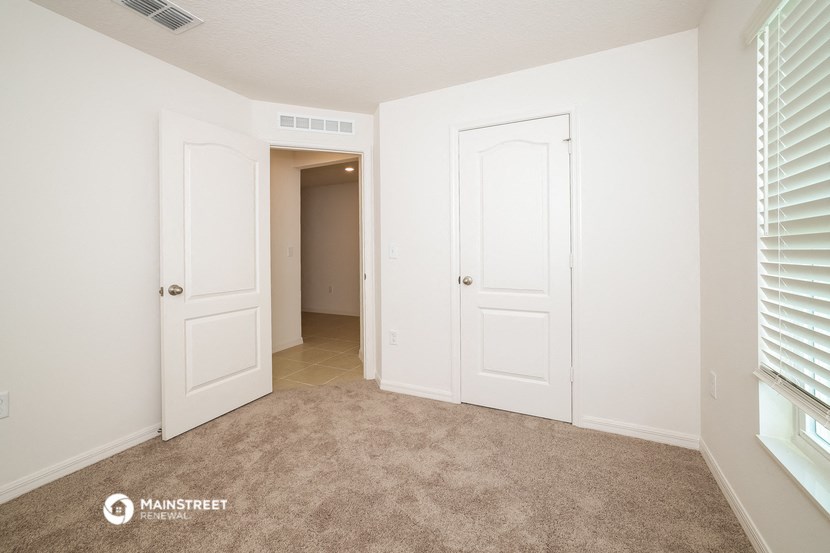 a bedroom with two closets and a door to a hallway