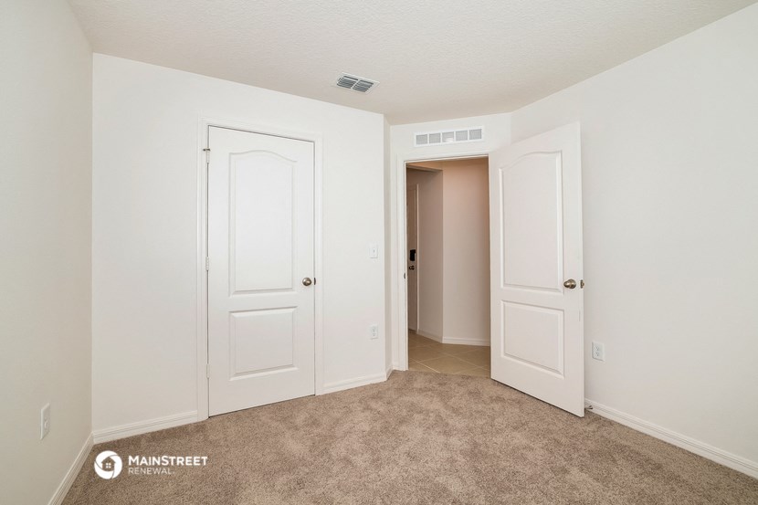 a bedroom with two closets and a door to a hallway