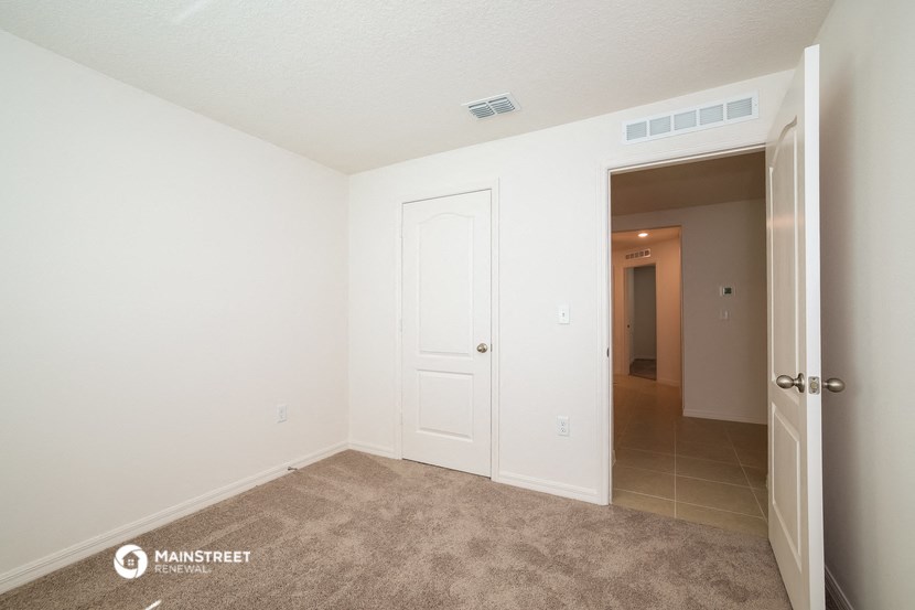 a bedroom with a closet and a door to a hallway