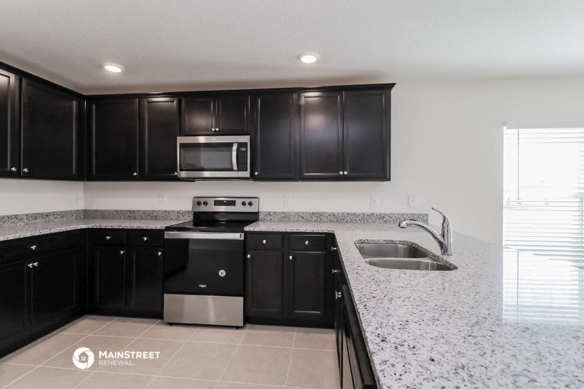 a kitchen with black and white granite counter tops and black cabinets
