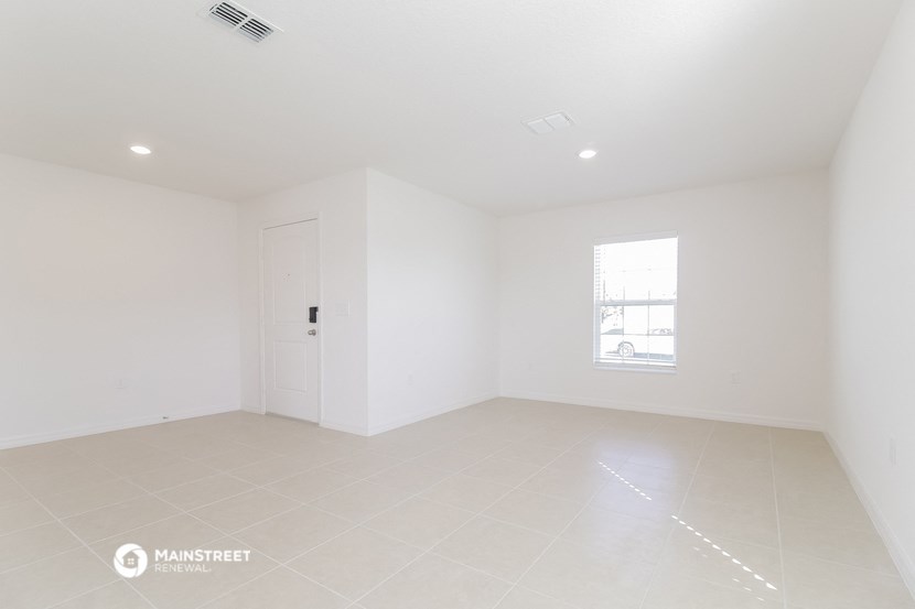 an empty room with white walls and tile floor and a door