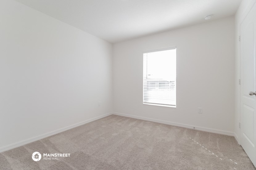 an empty room with a window and a door