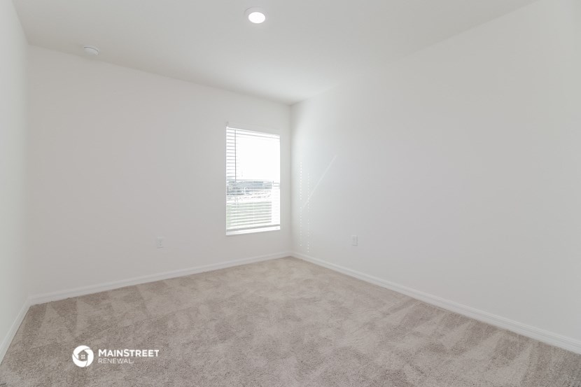 a room with a window and a carpeted floor