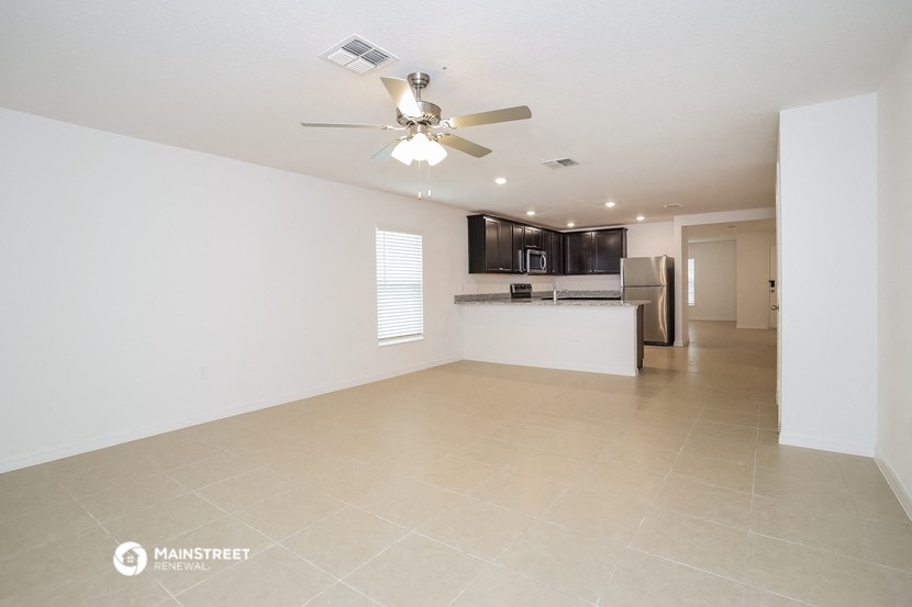 the spacious living room and kitchen in this apartment