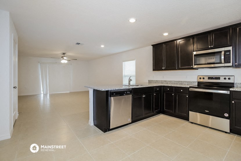 a kitchen with black cabinets and stainless steel appliances