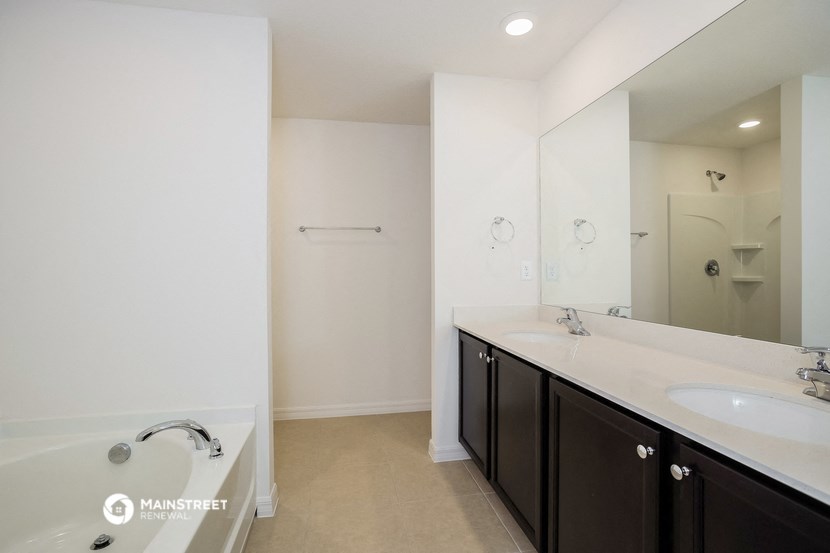 a bathroom with a tub and a sink and a mirror
