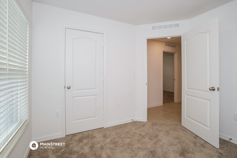 a bedroom with two closets and a door to a hallway