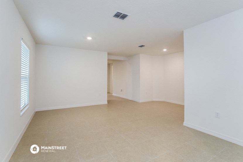an empty living room with white walls and a window