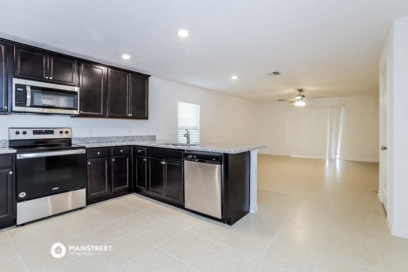 an empty kitchen with black cabinets and a counter top