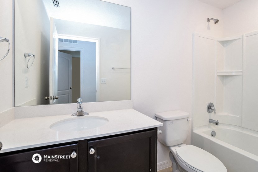 a bathroom with a sink toilet and a mirror