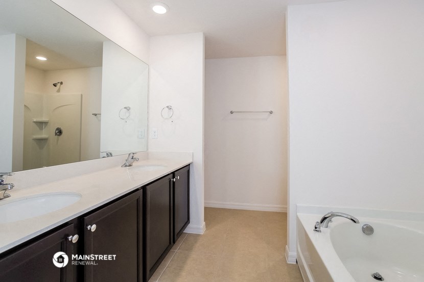 a bathroom with a tub and a sink and a mirror