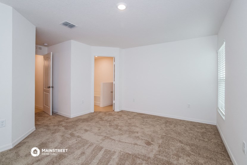 an empty living room with white walls and carpet