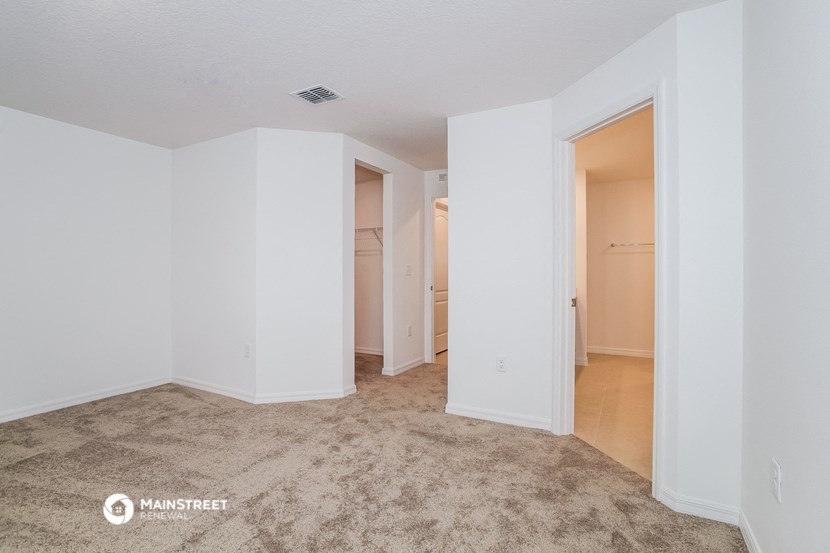 an empty living room with white walls and a closet