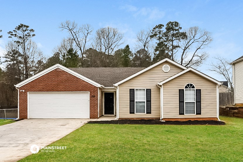 a tan house with a yard and a white garage door