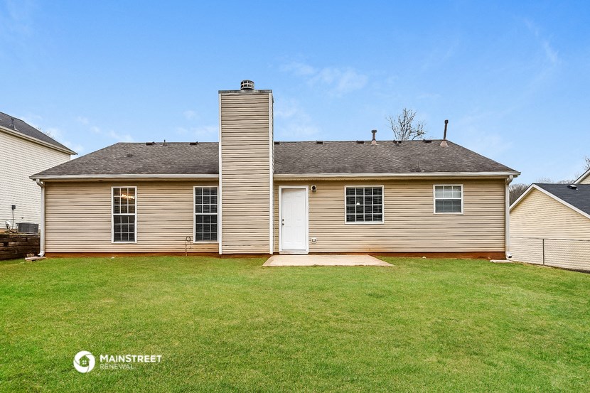 a brown house with a yard and a white door