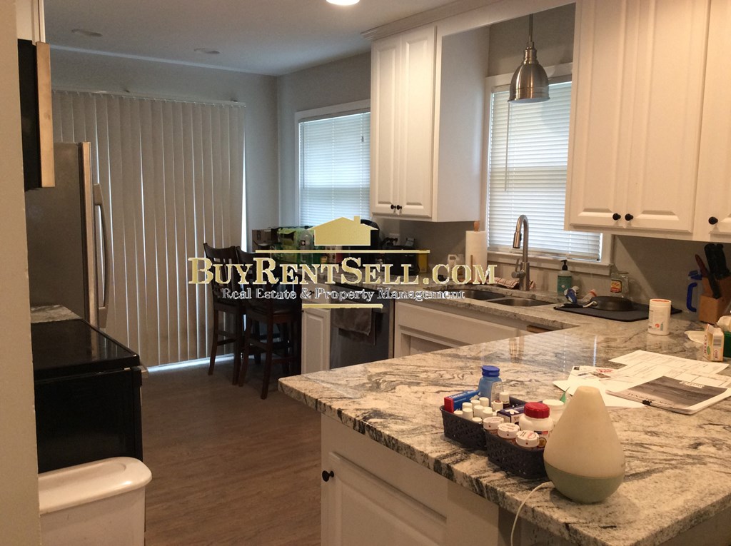 a kitchen with white cabinets and granite counter tops