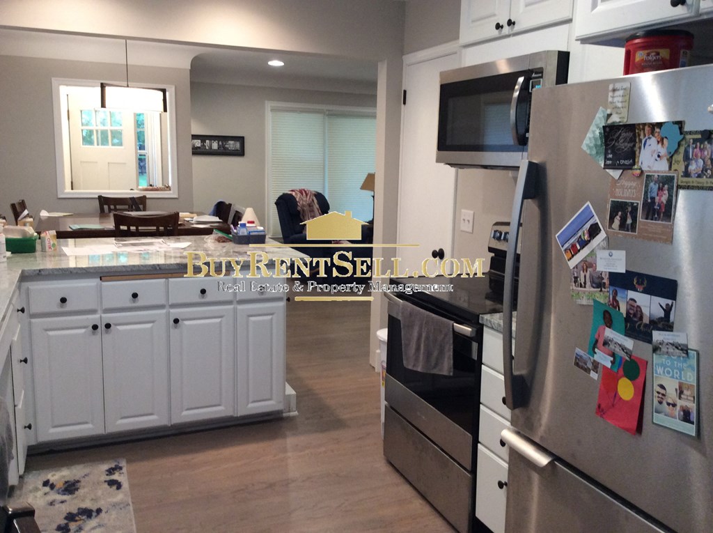 a kitchen with white cabinets and stainless steel appliances