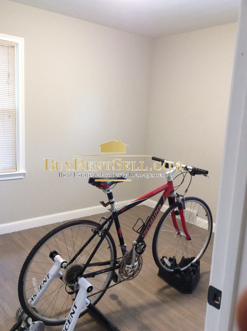 a bike in a room with a wall and a door