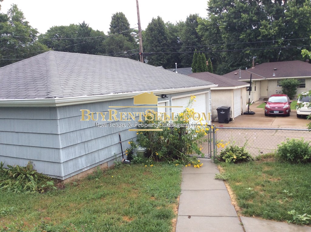 a house with a sign on the side of a driveway