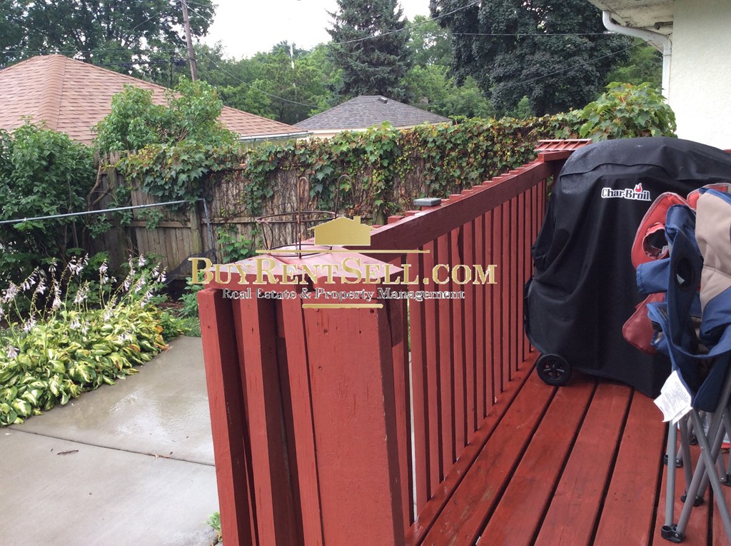 a back yard with a wooden fence and a stroller