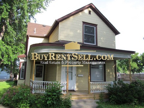 A house with a sign that says Buy Rent Sell.