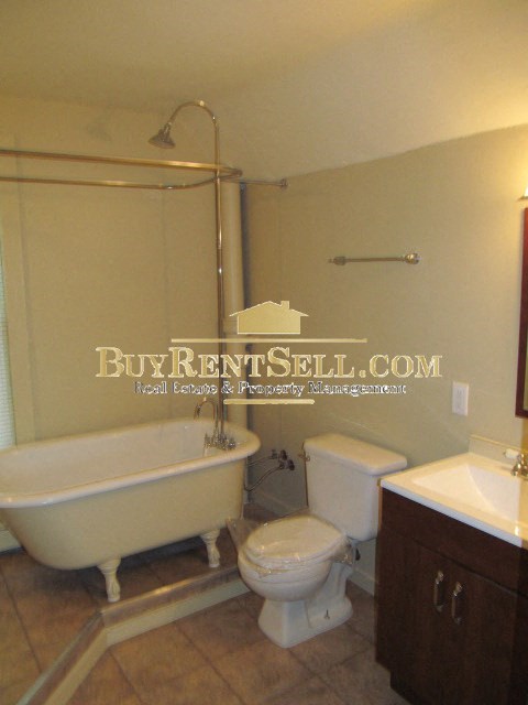 A white toilet sits next to a white sink in a bathroom.