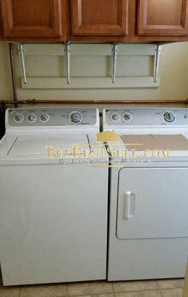 A white dishwasher and stove top oven in a kitchen.