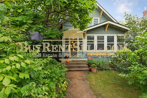 the front porch of a house with a path leading up to it