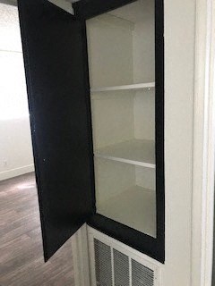 a black medicine cabinet with glass shelves on a door