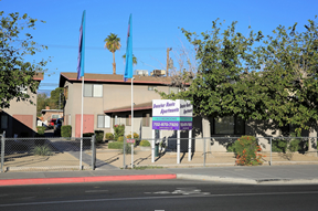 the front of a building with a blue and purple sign