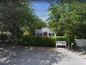 a house with a red door and a sign in front of it
