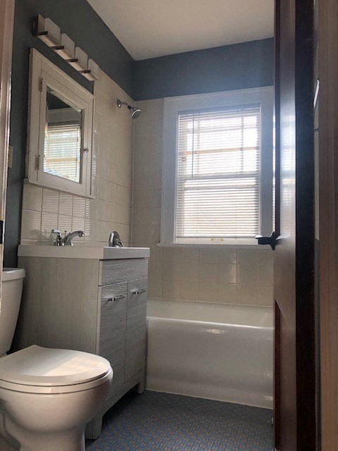 a bathroom with a toilet and a sink and a bath tub