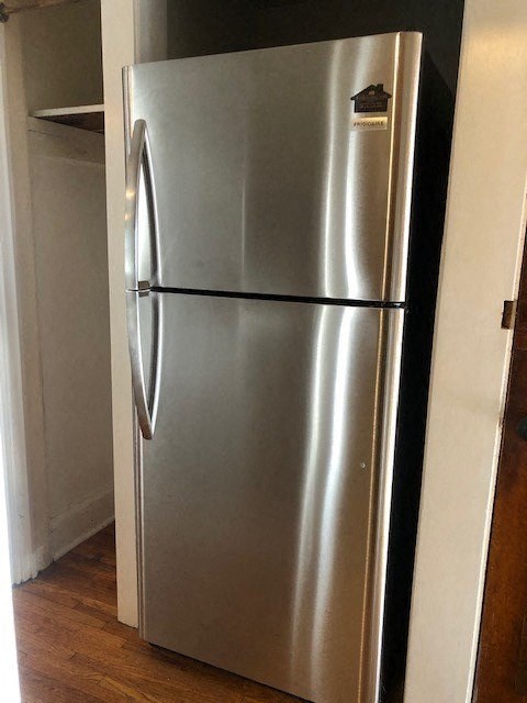 a stainless steel refrigerator in the corner of a room