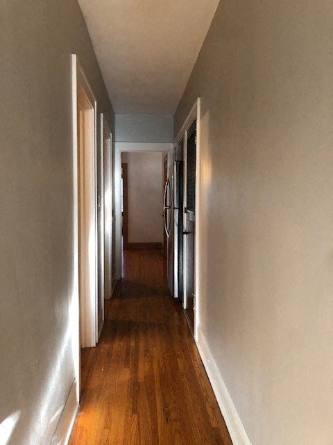 a hallway with a wood floor and white walls