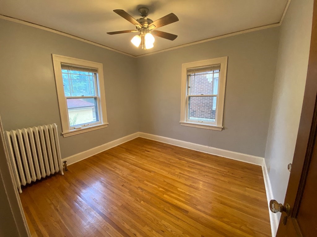 a living room with wood floors and a ceiling fan