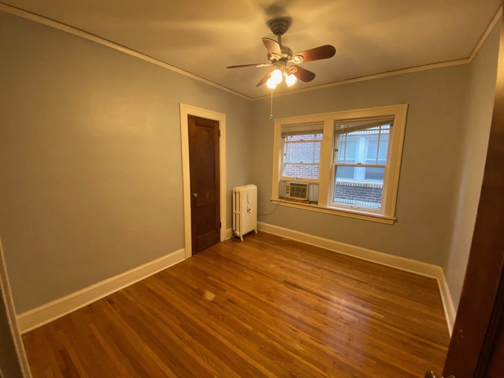 the living room of an empty house with a ceiling fan